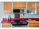 Modern kitchen featuring stainless steel appliances, light blue walls, and wooden cabinetry at 6461 Sunset Ln, Indianapolis, IN 46260