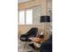 Comfortable sitting area featuring a mid-century modern chair, side table, and large window at 6461 Sunset Ln, Indianapolis, IN 46260