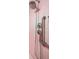 Close up of shower head, temperature controls, and grab bar in the retro pink bathroom at 6461 Sunset Ln, Indianapolis, IN 46260