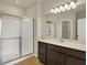 Bathroom featuring dark wood cabinets, double vanity, and a glass-enclosed shower with tile surround at 7158 Rose Hill Ave, Brownsburg, IN 46112