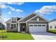 Beautiful exterior elevation with gray siding, stone accents, and a two-car garage on a well-manicured lawn at 7158 Rose Hill Ave, Brownsburg, IN 46112