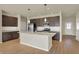 Modern kitchen featuring dark wood cabinets, a quartz island, pendant lighting, and stainless steel appliances at 7158 Rose Hill Ave, Brownsburg, IN 46112