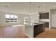 Open-concept kitchen with an island, stainless steel appliances, and hardwood floors at 7158 Rose Hill Ave, Brownsburg, IN 46112
