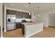 Stylish kitchen with stainless steel appliances, dark cabinets, subway tile backsplash, and a large island at 7158 Rose Hill Ave, Brownsburg, IN 46112