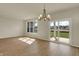 Open-concept living room with wood flooring, modern chandelier, and natural light from windows and glass door at 7158 Rose Hill Ave, Brownsburg, IN 46112