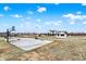 Basketball court with surrounding lawn, view of the farmhouse with long porch and garage at 7418 W Old Sr 252, Edinburgh, IN 46124
