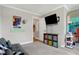 Bright room with wall-mounted TV, colorful storage bins, decorative horse head, and a cozy gray sofa at 7418 W Old Sr 252, Edinburgh, IN 46124