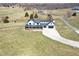 Aerial view showcasing a farmhouse with a wraparound porch and two-car garage at 7418 W Old Sr 252, Edinburgh, IN 46124