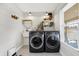 Laundry room with shiplap walls, modern black appliances, and patterned tile flooring at 7418 W Old Sr 252, Edinburgh, IN 46124