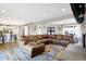 Open floor plan with a large leather sectional sofa connecting the kitchen, dining, and living spaces at 7418 W Old Sr 252, Edinburgh, IN 46124