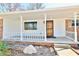 Inviting front porch with white railing, brick accents, and a classic wooden front door at 7953 Forest Park Dr, Indianapolis, IN 46217