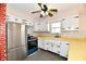 Bright kitchen with white cabinets, modern appliances, and a unique brick accent wall at 7953 Forest Park Dr, Indianapolis, IN 46217
