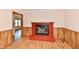 Living room showcasing a red brick fireplace, wood flooring, and wainscotting at 7953 Forest Park Dr, Indianapolis, IN 46217