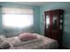 Bright bedroom with a large window, sheer curtains, and hardwood storage cabinet at 8137 S Delaware St, Indianapolis, IN 46227