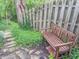 Backyard brick patio with wooden park-style bench and wooden fence surrounded by green foliage at 8510 N Park Ave, Indianapolis, IN 46240