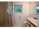 Cozy, tiled bathroom featuring a shower, toilet, vanity with a sink, and a bright window at 8510 N Park Ave, Indianapolis, IN 46240