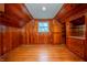 Wood-paneled bedroom featuring a window with shutters, built-in drawers, and wooden floors at 8510 N Park Ave, Indianapolis, IN 46240