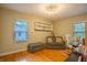 Bright bedroom featuring hardwood floors, large windows, a loveseat, and a modern light fixture at 8510 N Park Ave, Indianapolis, IN 46240