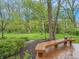 Spacious wood deck with built-in seating, overlooking a beautiful lawn with mature trees at 8510 N Park Ave, Indianapolis, IN 46240