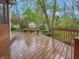 View of the stained wood deck with built in bench seating and lush green landscape at 8510 N Park Ave, Indianapolis, IN 46240
