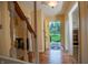Hallway featuring hardwood floors, a staircase, and a bright yellow front door with a view of the front yard at 8510 N Park Ave, Indianapolis, IN 46240
