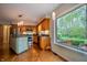 Bright kitchen with hardwood floors, wooden cabinets, stainless steel appliances, and a large window overlooking greenery at 8510 N Park Ave, Indianapolis, IN 46240