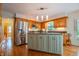 Well-lit kitchen with a center island, hardwood floors, wooden cabinets, and modern stainless steel appliances at 8510 N Park Ave, Indianapolis, IN 46240