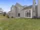 An exterior shot of the backyard featuring a well kept lawn, sliding glass door, and wall of windows at 9459 Wimbledon Ct, Indianapolis, IN 46250