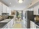 Well-lit kitchen with white cabinets, stainless steel refrigerator, and a view of the dining area at 9459 Wimbledon Ct, Indianapolis, IN 46250