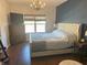 Bedroom features a queen bed, wood floors, a chandelier, and natural light through a window at 950 Kempson Ct, Westfield, IN 46074