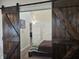 Bedroom view through open sliding barn doors, showcasing a comfortable bedroom with a woven blanket at 9649 Cedar Cove Ln, Indianapolis, IN 46250