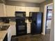 Bright kitchen with white cabinetry, black appliances, and view to the dining room at 9649 Cedar Cove Ln, Indianapolis, IN 46250