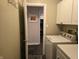 Convenient laundry room with white cabinets and modern appliances, with view into kitchen at 9649 Cedar Cove Ln, Indianapolis, IN 46250