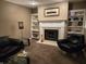 Cozy living room featuring a fireplace, built-in shelves, and comfortable black leather seating at 9649 Cedar Cove Ln, Indianapolis, IN 46250