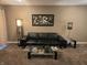 Relaxing living room with a large black sofa, glass coffee table, and stylish lighting at 9649 Cedar Cove Ln, Indianapolis, IN 46250