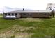 Picture of the backyard of the single-story home with a metal roof and a propane tank at 10966 W State Road 142, Quincy, IN 47456