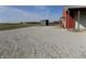 The exterior of the barn features a red facade and white doors, complemented by a gravel driveway at 10966 W State Road 142, Quincy, IN 47456