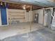Partially finished basement space featuring storage shelves, water heaters, and painted walls at 10966 W State Road 142, Quincy, IN 47456