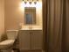 Bathroom boasts a white vanity with updated fixtures, a modern mirror and shower curtain at 10966 W State Road 142, Quincy, IN 47456