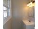 Bathroom features a white vanity with updated fixtures and a window providing ample natural light at 10966 W State Road 142, Quincy, IN 47456