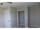 Bedroom features an open closet space, neutral walls, carpet flooring, and overhead ceiling fan at 10966 W State Road 142, Quincy, IN 47456