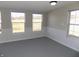 Bonus room features carpet flooring, neutral walls, wainscotting, and several windows providing natural light at 10966 W State Road 142, Quincy, IN 47456