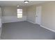 Bonus room features carpet flooring, neutral walls, wainscotting, and a door to the backyard at 10966 W State Road 142, Quincy, IN 47456