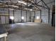 The insulated garage features a functional layout with high ceilings, ample lighting, and white insulated walls at 10966 W State Road 142, Quincy, IN 47456