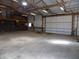 The insulated garage features a functional layout with high ceilings, ample lighting and an oversized door at 10966 W State Road 142, Quincy, IN 47456