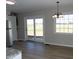 Modern kitchen with white cabinets, stainless steel appliances, and a backyard view through double doors at 10966 W State Road 142, Quincy, IN 47456
