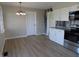 Bright kitchen featuring white cabinets, stainless steel appliances, and wood laminate flooring at 10966 W State Road 142, Quincy, IN 47456