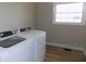 Functional laundry area featuring modern washer and dryer units beneath a bright window at 10966 W State Road 142, Quincy, IN 47456