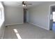 Neutral living room with a ceiling fan, large window and entryways on both sides of the room at 10966 W State Road 142, Quincy, IN 47456