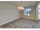 Bright dining room featuring wood floors, a modern light fixture, and a large window letting in natural light at 11144 Echo Trl, Indianapolis, IN 46236